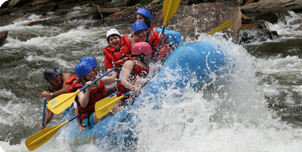 People smile and laugh as they go white water rafting.